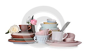 Set of clean tableware with flowers on white background