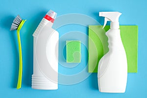 Set of cleaning supplies on blue background. House cleaning service and housekeeping concept. Flat lay, top view