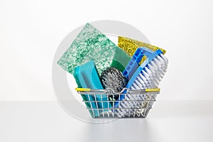 Set for cleaning and washing dishes in a metal basket on a white table.