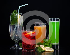 A set of cocktails of fresh fruit juices on a black background