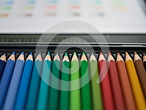Assorted color pencils, crayons, in a metal box