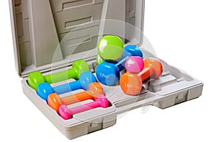 A set of colored isolated dumbbells for sports on a white background is stacked in a gray case