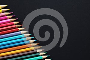 Set of colored pencils on a black background - copy space