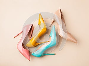 Set of colored women`s shoes on beige background