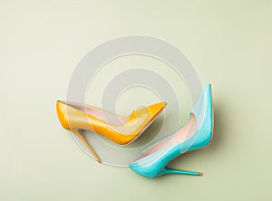 Set of colored women`s shoes on green background