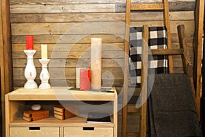 Set of colorful candles on wooden chest of drawers near wall at house