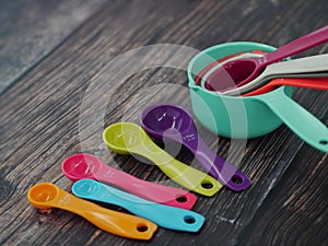 Set of colorful measuring cups and measuring spoons use in cooking lay on wood tabletop in top view