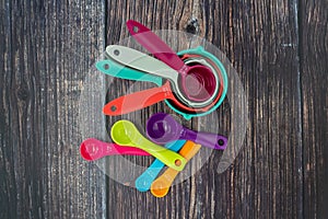 Set of colorful measuring cups and measuring spoons use in cooking lay on wood tabletop in top view