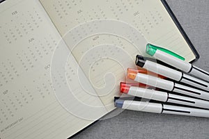 Set of colorful pen placed on calendar notebook.