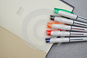 Set of colorful pen placed on planner book.