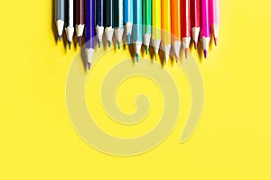 Set of colorful pencils on a yellow background. Copyspace, frame. Back to school, artist, drawing lessons. Stationery for