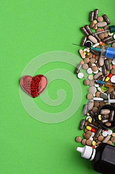 Set of colorful pills scattered on green background