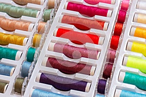 A set of colorful threads and plastic bobbins for sewing machines