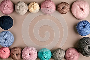 Set of colorful wool yarn on beige background. Top view. Frame of tangles of knitting threads