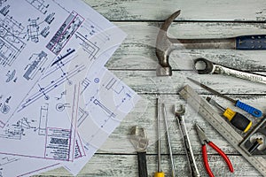 Set of construction tools and blueprints on the white,rustic wooden background