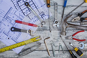 Set of construction tools and blueprints on the white,rustic wooden background