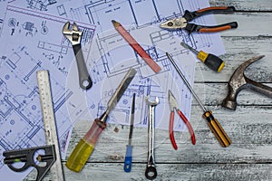 Set of construction tools and blueprints on the white,rustic wooden background