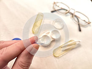 A set for contact lenses with a container, forceps, glasses. The concept of correcting myopia. Contact lens care