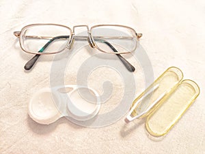 A set for contact lenses with a container, forceps, glasses. The concept of correcting myopia. Contact lens care