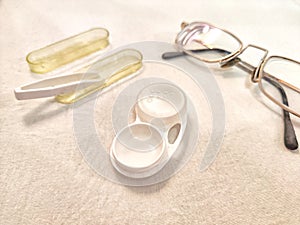 A set for contact lenses with a container, forceps, glasses. The concept of correcting myopia. Contact lens care