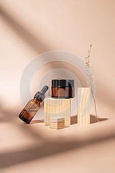 Set of cosmetic products in amber glass package. Beauty oil in dropper glass bottle and amber glass jar with day cream