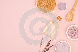 Set of cosmetic products for spa body care treatments at home on a gentle rose background with space for text