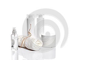 Set of cosmetic products in white containers on light background.