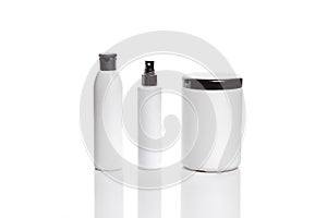 Set of cosmetic products in white containers on light background.