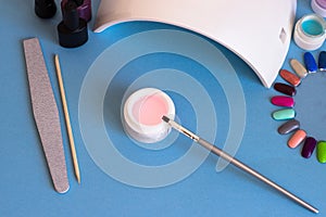 Set of cosmetic tools for manicure and pedicure on a blue background.