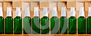 Set of cosmetics bottles with a body care liquid spray on the wooden tiled table