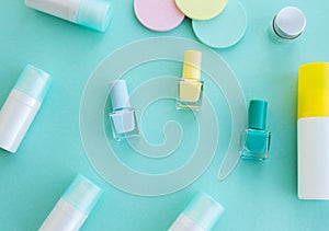 Set of cosmetics on a green background with varnishes, bottles with creams. Flat lay