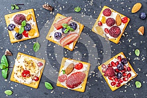 Set of crackers with various fruit close-up on black stone plate