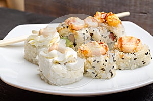 A set of cut Japanese sushi rolls on a white plate closeup
