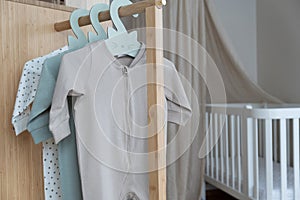 Set of cute bodysuits for newborn on hangers. Copy space. The concept of baby clothes, motherhood, fashion. Nursery
