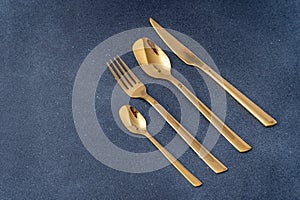 Set of cutlery made of gold metal. Fork, spoon, knife, teaspoon.