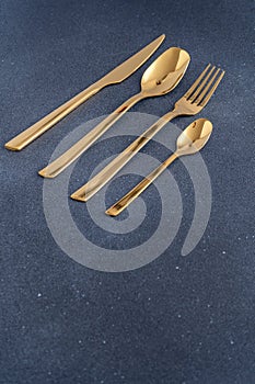 Set of cutlery made of gold metal. Fork, spoon, knife, teaspoon.