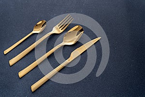 Set of cutlery made of gold metal. Fork, spoon, knife, teaspoon.