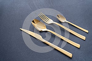 Set of cutlery made of gold metal. Fork, spoon, knife, teaspoon.