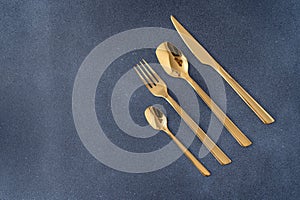 Set of cutlery made of gold metal. Fork, spoon, knife, teaspoon.