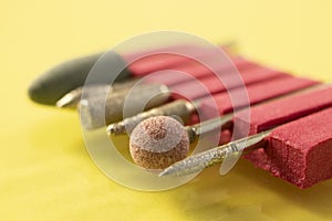 set of cutters for manicure on a light yellow background. The tools are used by manicurists.