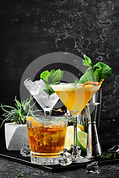 A set of delicious colored alcoholic cocktails. On a black background.