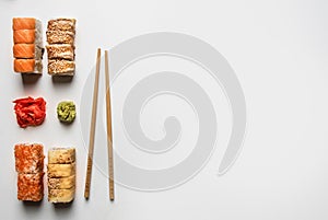 Set of delicious sushi with ginger and wasabi on a white background, space for text