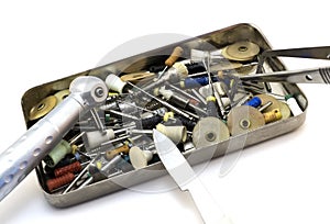 Set dental instruments: cutters, needles, drills, scalpel, forceps in a metal box isolated