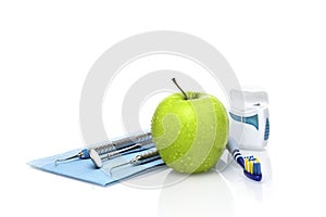 Set of dentist medical equipment tools with fresh green apple dental health care conceptual background image.- Image