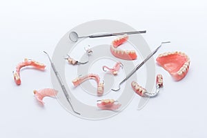 Set of dentures and dental tools on white background