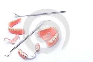 Set of dentures and dental tools on white background photo