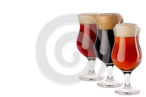 Set of different beer in wineglasses with foam - lager, red ale, porter - isolated on white background.