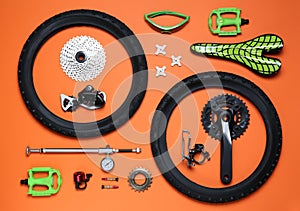 Set of different bicycle tools and parts on orange background, flat lay