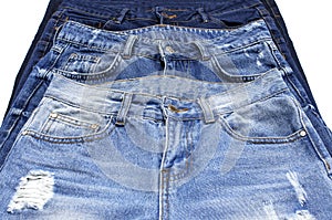 Set of different blue jeans isolated on white background top view flat lay. Detail of nice blue jeans. Jeans texture or denim