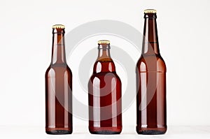 Set of different brown beer bottles 500ml and 330ml mock up. Template for advertising, design, branding identity on white wood ta photo